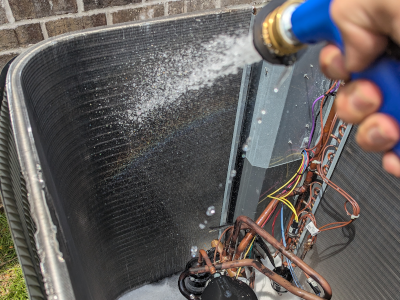 AC maintenance technician cleaning a coil as part of a tune-up in Navarre, FL